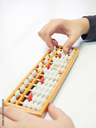 Classes in mental arithmetic  hands and abacus soroban on white background. closeup