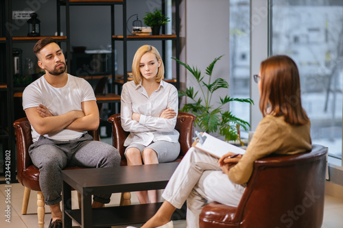 unhappy married couple talking to family psychologist before breaking up, consulting family relationships expert, trying to save married couple. relationships, people, family, psychology concept