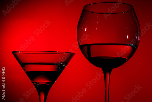 two glasses of water in red light.