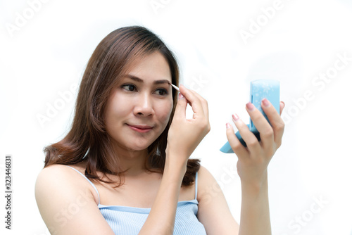 Healthy fresh girl  use cosmetic to makeup her face. Beauty woman makeup her face with with cosmetic isolated on white background. Skin care and beauty concept.