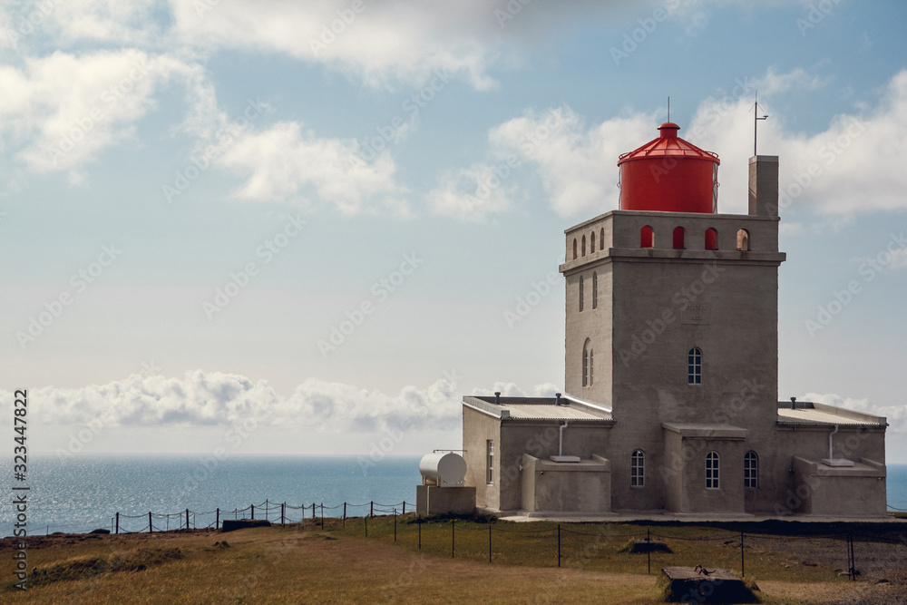 Lighthouse at Dyrholaey Cape in South Iceland on beautiful sky background. Place for text or advertising