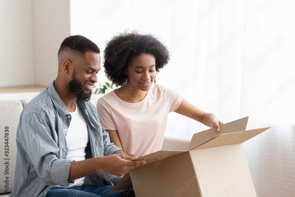 Happy afro man and woman customer unbox package order