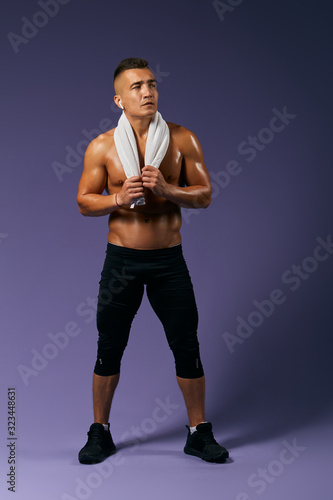 sweaty athlete going to have a shower after training, full length photo. isolated blue ackground, studio shot. full length photo. tiredness