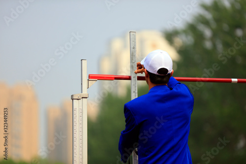high jump field staff are adjusting the height