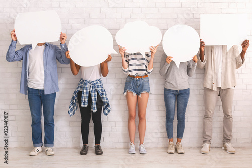 Group of teenagers hiding behind speech bubbles
