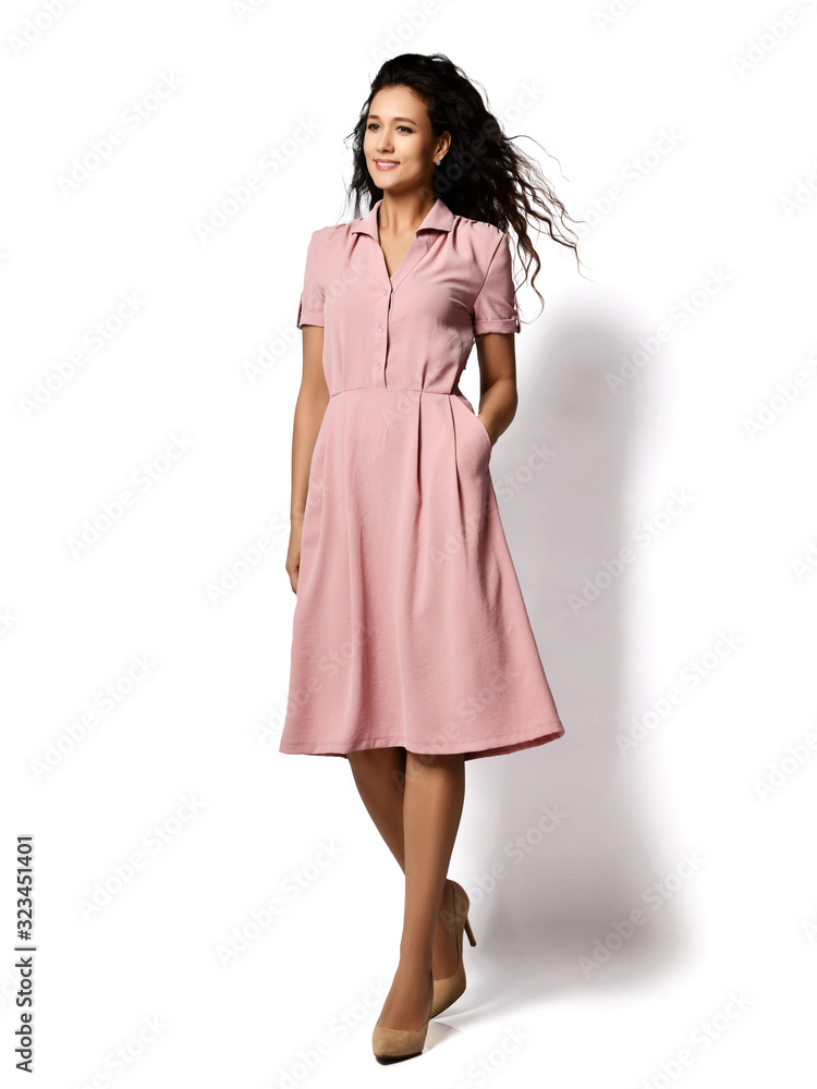 Young beautiful woman posing in new fashion casual pastel pink color dress happy smiling walking full body Young beautiful woman posing in new fashion casual pastel pink color dress happy smiling walking full body