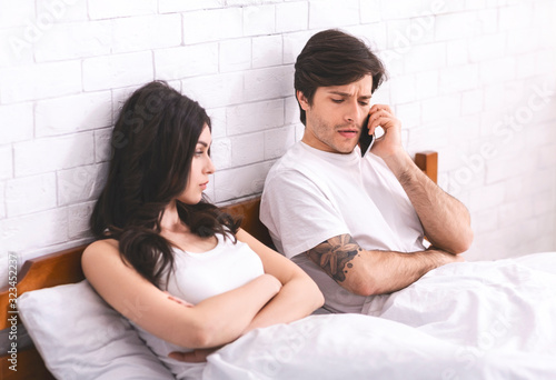 Worried man calling family counselor after quarrel with wife photo