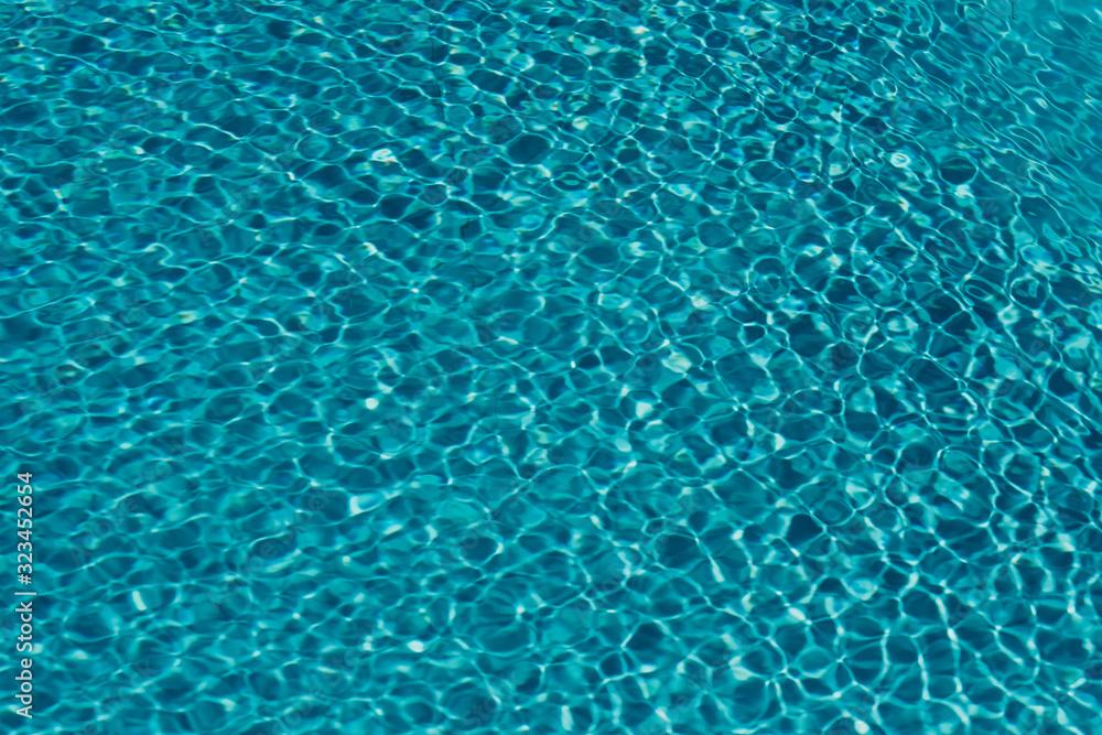 surface of blue swimming pool,background of water in swimming pool sunlight impact