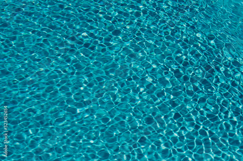 surface of blue swimming pool,background of water in swimming pool sunlight impact