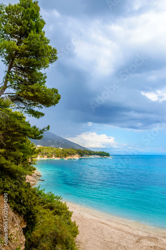 Coast near Zlatni Rat or Golden Horn beach in Bol town on Brac Island, Croatia with pine trees and turquoise sea water