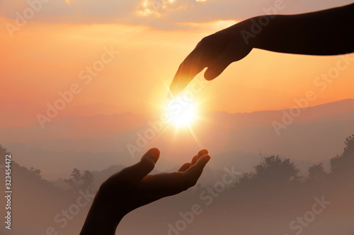 Giving a helping hand on the background of the sunset.