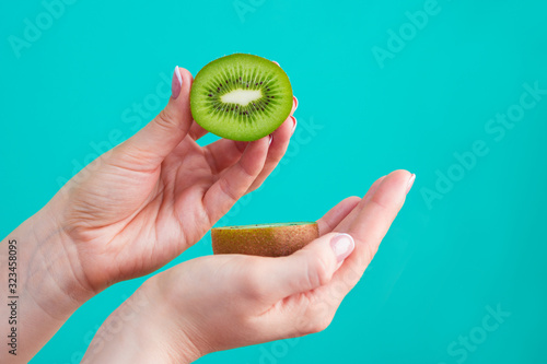 woman hand holding kiwi fruit half