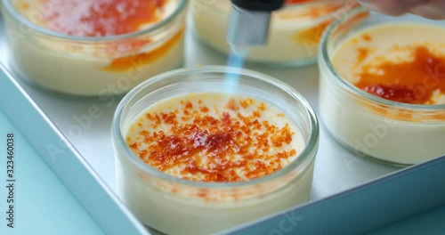 Caramelizing sugar on the top of creme brulee dessert using gas torch