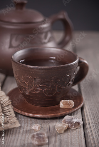 Cup of tea and sugar with teapot on the background