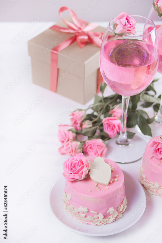 Mini small cake with pink glaze, beautiful roses, cup of coffee, gift box on the white table. Mini small cake with pink glaze, beautiful roses, cup of coffee, gift box on the white table.