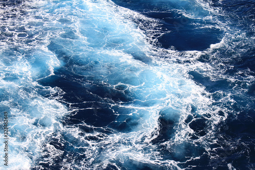 Obraz na płótnie Ocean waves wallpaper, Dark blue water and sea foam from aerial view, Natural abstract pattern background with copy space for web banner and design template. w salonie