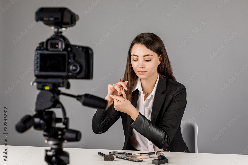 Young blogger in dark suite on grey background. Young blogger in dark suite on grey background.