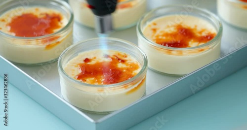 Caramelizing sugar on the top of creme brulee dessert using gas torch