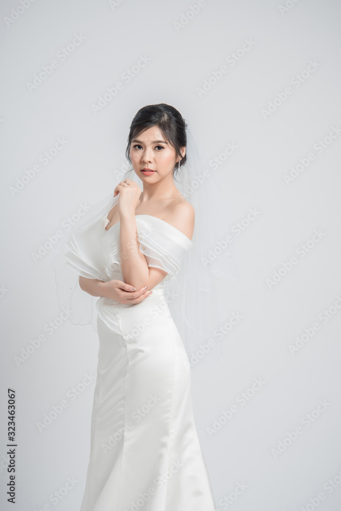 young Asian bride in wedding dress on grey background young Asian bride in wedding dress on grey background