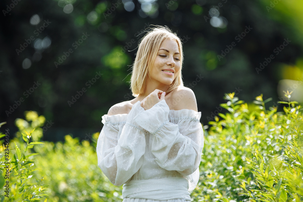blonde in a white dress and a beautiful smile in the backlight blonde in a white dress and a beautiful smile in the backlight