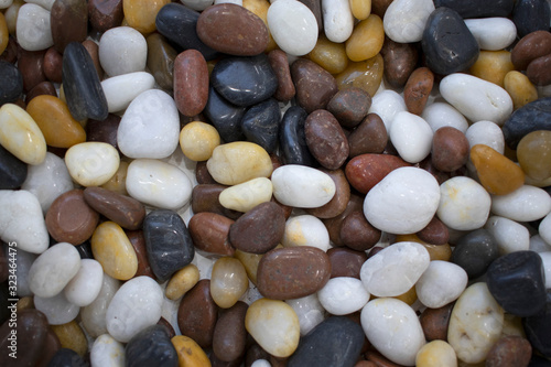Background from sea pebbles of different colors, white, black brown. Ocean pebbles round, stone marine closeup. Backdrop design background, place to insert text, copy spase