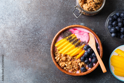 Asai bowl granola oatmeal with mango, blueberry and chia seeds in wooden plate photo