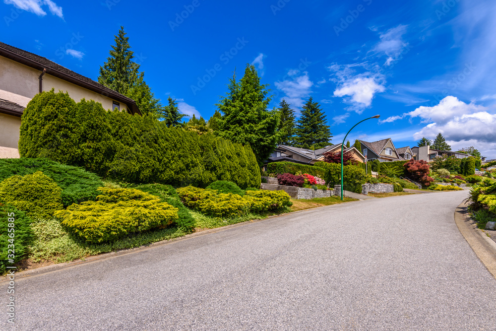 A perfect neighborhood. Houses in suburb at Summer in the north America. Fragment of a luxury house with nice window over blue sky.