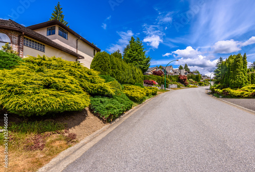 A perfect neighborhood. Houses in suburb at Summer in the north America. Fragment of a luxury house with nice window over blue sky.