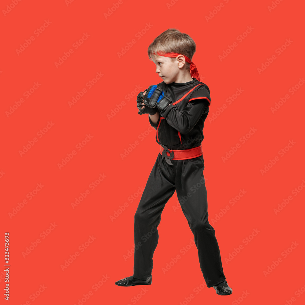Full lenght portrait of young boy in kimono posing in karate position on red background Full lenght portrait of young boy in kimono posing in karate position on red background
