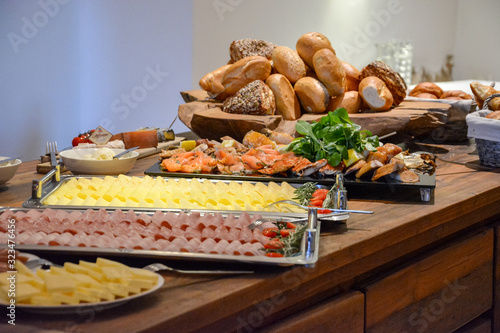 Breakfast buffet with rolls, cheese and several vegetables