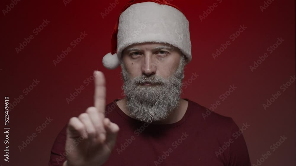 Portrait of Santa Claus making expressions on red background - shows sign of disagreement with finger, slow motion Portrait of Santa Claus making expressions on red background - shows sign of disagreement with finger, slow motion