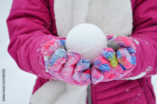 Girl holding snow ball with both hands