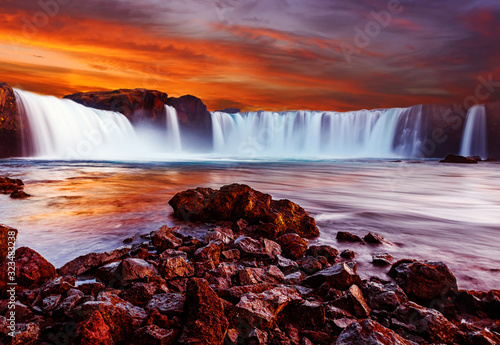 Scenic image of Iceland. Wonderful Nature landscape. Great view on famous Godafoss Waterfall with Colorful  red sky during sunset. Popular Travel destinations. Picture of wild area.