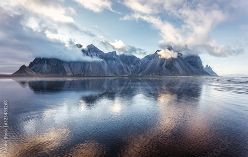 Wonderful nature landscape. Impressive view on Famous Vestrahorn Mountain in clouds with reflection. Popular travel location. Stokksnes cape the most famous place of Iceland. Beauty in the world