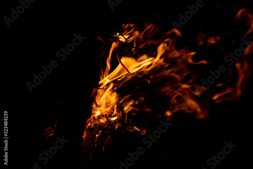 Lodernde Flammen eines romantischen Lagerfeuers beim Camping erhöhen Brandgefahr und Gefahr von Brandwunden ebenso wie Waldbrand und Verbrennungen von Würstchen und Grillgut © sunakri