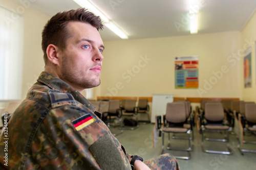 German soldier sits in a classroom . German word Bundeswehr, means german army.