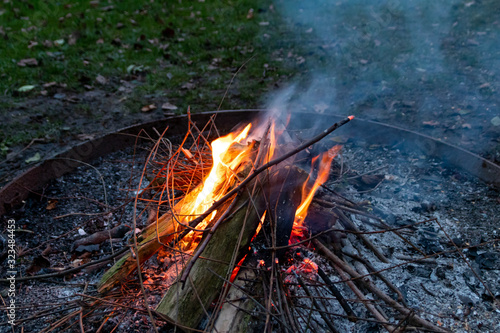 Brennendes Lagerfeuer mit romantischem Licht erhellt die Dunkelheit für gemütliches Camping mit der Familie, Grillen und Stockbrot bei wärmendem Feuer und Abenteuer