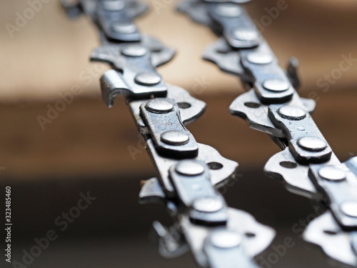 metal chainsaw chain with sharp teeth close-up with blurred background photo