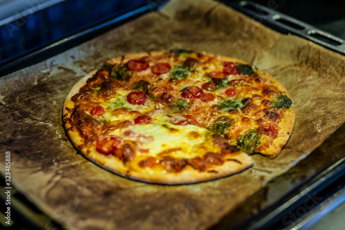 Newly baked pizza with tomato, mozzarella, onion, broccoli and cheese