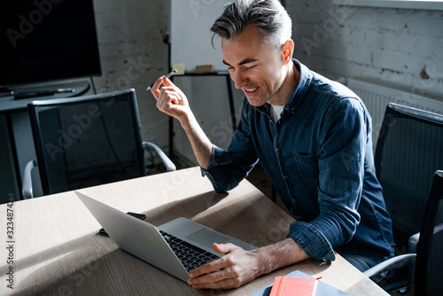Multi-ethnic contented person feels confident in creative office. Successful businessman smiling. Successful business strategy plan concept. Confident office worker indoor in coworking