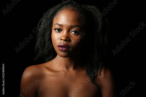 Wallpaper Mural Portrait of a young beautiful African woman with thick black curly hair on an isolated black background Torontodigital.ca