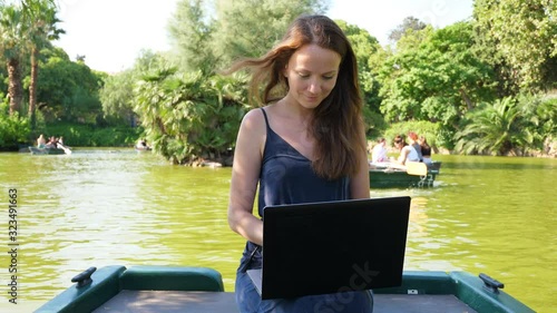 Woman with laptop work remotely at summer park