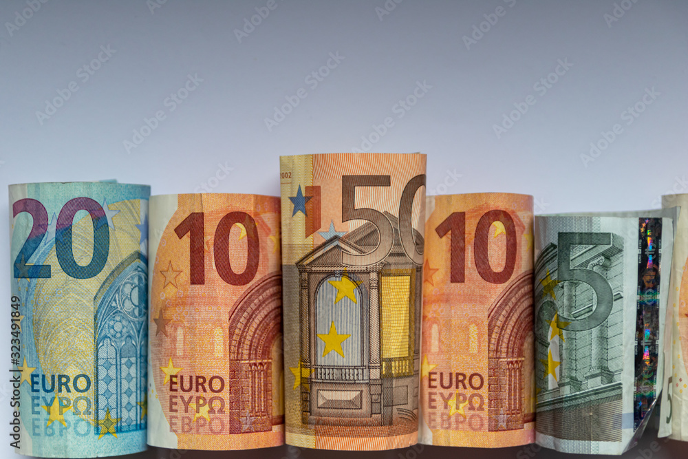 Beleuchtete und gerollte Euro-Geldscheine aus 20 euro, 50 euro, 10 euro und 5 euro Banknoten zeigen Profit, Gewinn, Ersparnisse und Dividenden im europäischen Finanzmarkt und Währungskursen Beleuchtete und gerollte Euro-Geldscheine aus 20 euro, 50 euro, 10 euro und 5 euro Banknoten zeigen Profit, Gewinn, Ersparnisse und Dividenden im europäischen Finanzmarkt und Währungskursen
