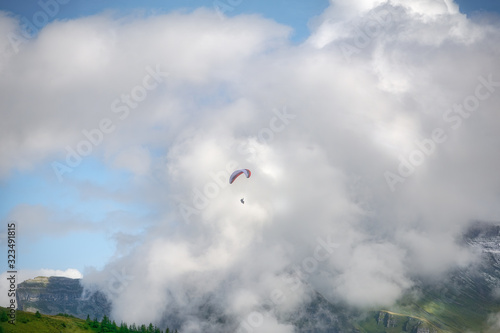 Paraglide flying over a valley in the Swiss Alpine mountains