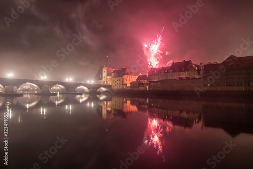 Silvester Feuerwerk in Regensburg mit Blick auf den Dom und die steinerne Brücke, Silvester 2019-2020, Deutschland © stgrafix