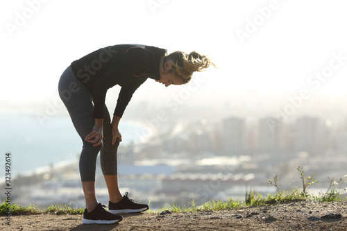 Exhausted runner resting after hard sport photo