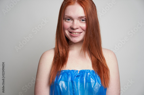 Fotografija Portrait of a beautiful red-haired woman in a plastic blue bag, who looks direct