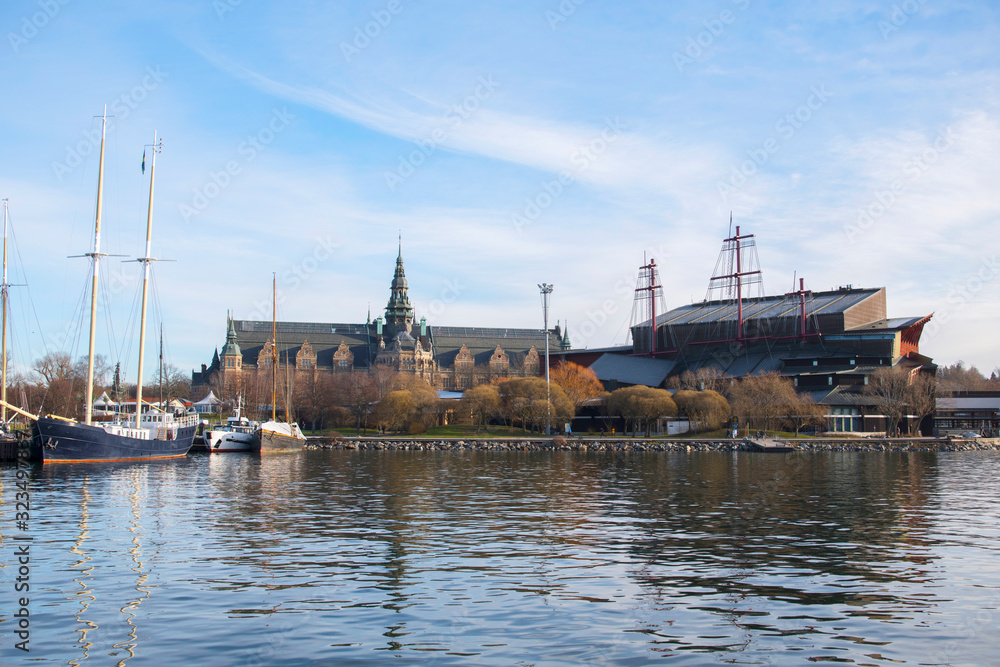 Sailing boats at the jettys on the island Djurgården with museum and park areas in Stockholm a winter day Sailing boats at the jettys on the island Djurgården with museum and park areas in Stockholm a winter day