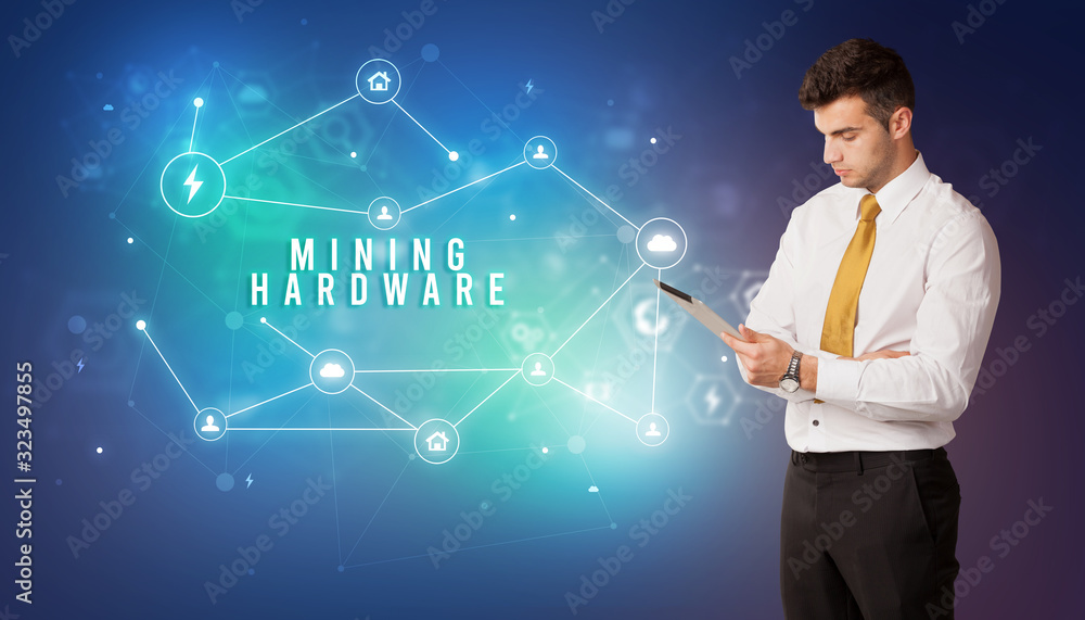 Businessman in front of cloud service icons with MINING HARDWARE inscription, modern technology concept Businessman in front of cloud service icons with MINING HARDWARE inscription, modern technology concept
