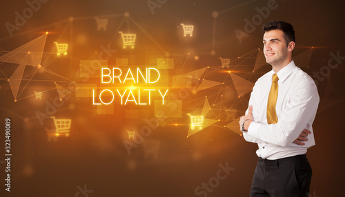 Businessman with shopping cart icons and BRAND LOYALTY inscription, online shopping concept